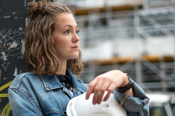 Thoughtful and contemplative factory female employee resting during the work break outdoors