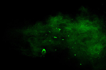 Green powder explosion on black background.Green dust particles splash.