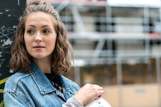 Thoughtful and contemplative factory female employee resting during the work break outdoors
