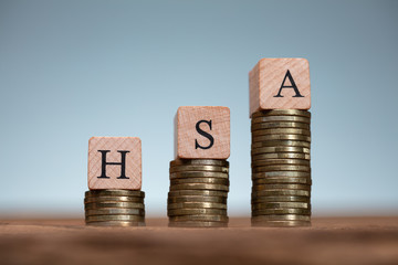 Health Savings Account Wooden Blocks On Coin Stacks