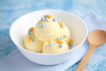 vanilla ice cream and candy on a blue background with a blank space for a text, vanilla ice cream in white ceramic cup