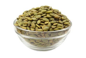 Pumpkin seeds in glass bowl isolated on white