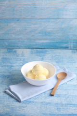 vanilla ice cream on a blue background with a blank space for a text, vanilla ice cream in white ceramic cup