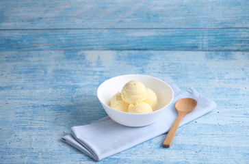 vanilla ice cream on a blue background with a blank space for a text, vanilla ice cream in white ceramic cup