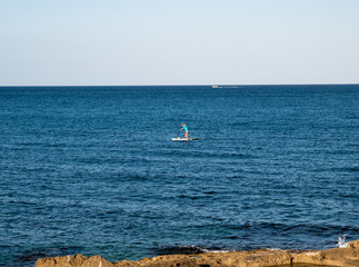 Naklejka premium man doing paddle surf in the sea