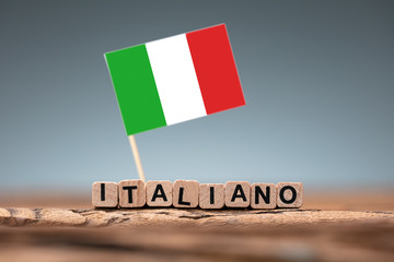 Italian Word Formed Using Wooden Block And Flag