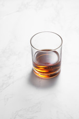 scotch whiskey in glass on a white marble table with a blank space for a text, scotch whiskey in bar background
