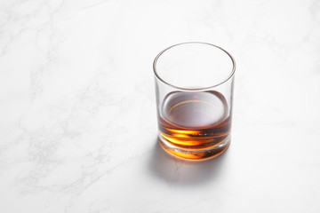 scotch whiskey in glass on a white marble table with a blank space for a text, scotch whiskey in bar background