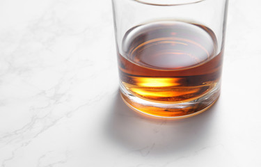 scotch whiskey in glass on a white marble table with a blank space for a text, scotch whiskey in bar background