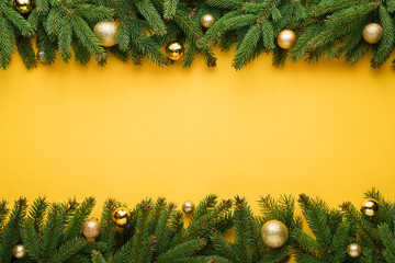 Christmas background with fir tree border and decoration on yellow