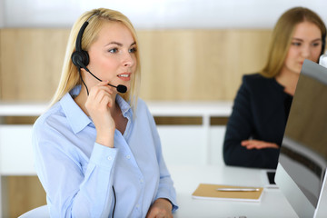 Call center. Blonde business woman sitting in headset at customer service office. Concept of telesales business or home office occupation