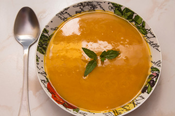 bowl with pumpkin soup on background