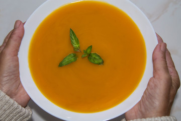 woman holding bowl of vegetable soup