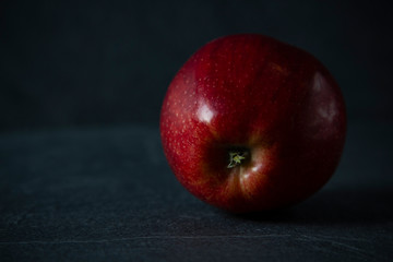 red apple against black stone background with space for text