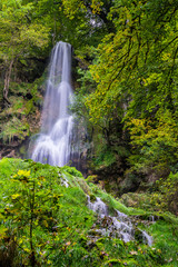 Fototapeta na wymiar Germany, Amazing tall 37 meters high waterfall of bad urach in climatic spa region of swabian alb nature landscape hidden in green jungle like forest, a popular tourist attraction