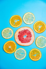 bright slices of oranges and grapefruit on a blue background - 296910740