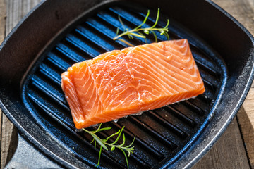 Fresh raw salmon fish served on cast iron grill pan