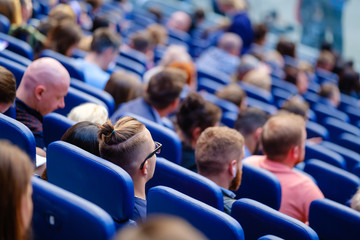 Business conference attendees sit and listen