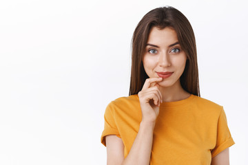 Pensive good-looking daring young modern woman in yellow t-shirt smiling sassy and creative,...