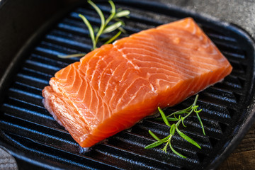 Fresh raw salmon fish served on cast iron grill pan