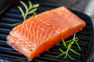 Fresh raw salmon fish served on cast iron grill pan