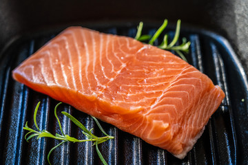 Fresh raw salmon fish served on cast iron grill pan