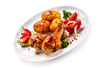 Grilled chicken drumsticks with baked potatoes and vegetables