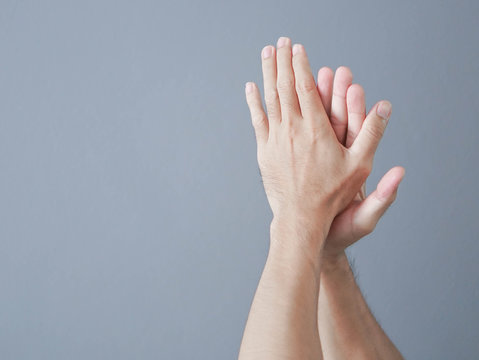Man clapping hands on grey background
