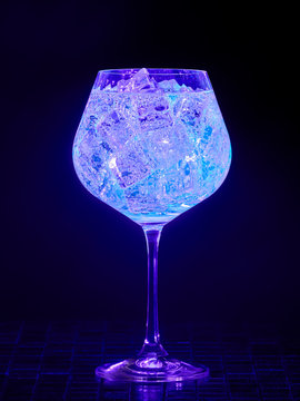 Gin tonic under blacklight (UV) illumination. Glow in the dark drink.   