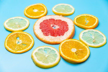 Fototapeta na wymiar bright slices of oranges and grapefruit on a blue background