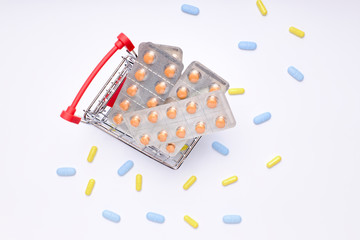 shopping cart with pills, medicines and bottles of medicines on white background. pharmacy medicines.