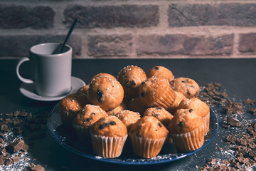 cup of milk together with some tasty muffins on a plate