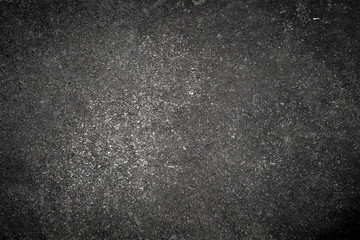 Dark grey stone texture with rough surface and small bubbles