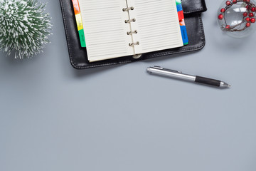 Top view of blank notebook, mini Christmas tree and Christmas ornament ball on gray  background. Flat lay with copy space.