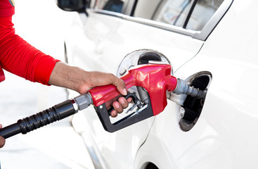 A white car refueling at a gas station