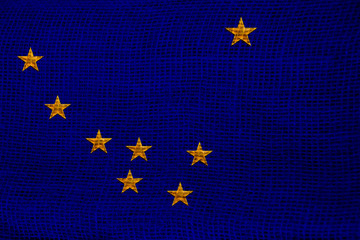 Photo of the national flag of Shatat Alaska USA on a luxurious texture of satin, silk with waves, folds and highlights, closeup, copy space