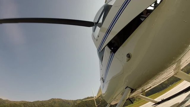 helicopter is preparing to take off, the pilot closes the door. Small lightweight aviation. bottom view on a propeller blades