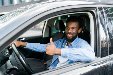 happy african man giving thumb up inside car