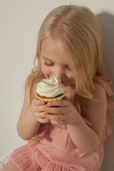 Little girl eats sweet cake with cream