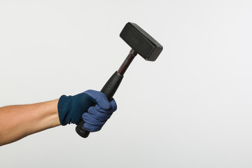hand in work glove holding a locksmith's hammer