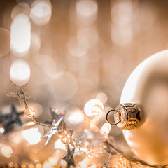 Christmas decorations in bright gold shiny colors with Christmas lights with blurred background.