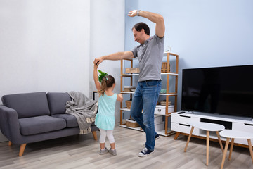 Father Dancing With Her Daughter At Home