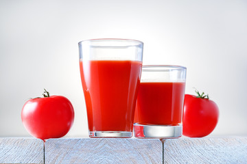 Glasses of fresh tomato juice on wooden table. Healthy food and drink.