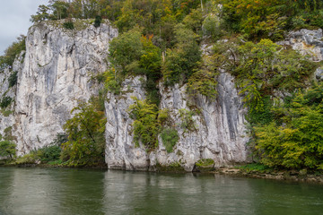 Obraz na płótnie Canvas Danube river at Danube breakthrough near Kelheim, Bavaria, Germany in autumn with limestone rock formations and plants with colorful leaves