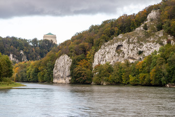 Fototapeta na wymiar Nature reserve at Danube river breakthrough near Kelheim, Bavaria, Germany in autumn with limestone rock formations and Befreiungshalle on the Michelsberg in the background