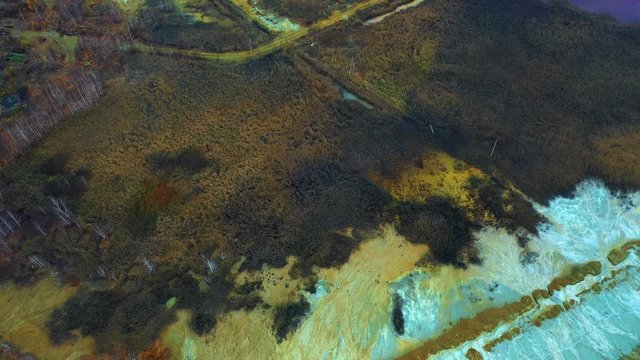 Polluted and abandoned industrial ground with red toxic water, aerial view. Ural Russia Karabash