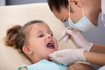 Obraz na płótnie Canvas Girl Having His Teeth Examined By A Dentist