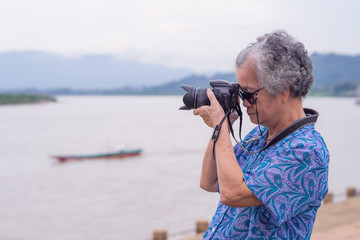 Senior woman using a camera to take photo