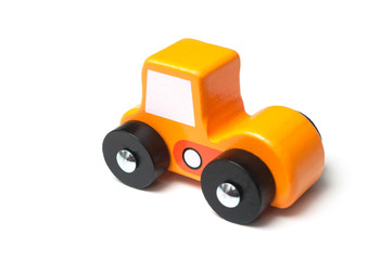 Closeup of miniature toy, wooden orange color car on white background