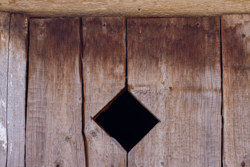 old wooden fence texture background with diamond shaped hole
